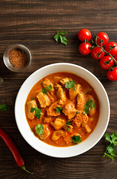  Indian dish chicken tikka masala in bowl on wooden background