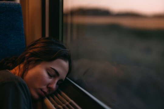Resting peacefully while journeying on the train at sunset