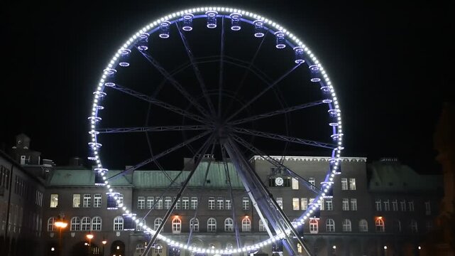 Illuminated Ferris wheel at night on Dom Square in Szeged, Hungary, during a winter festival.