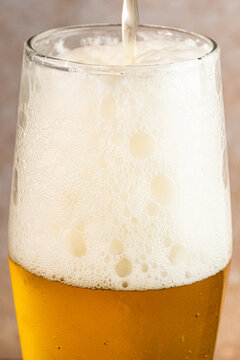 Closeup of a glass of beer with foam and water droplets 