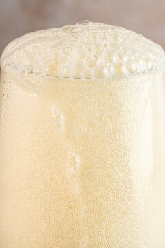 Closeup of a glass of beer with foam and water droplets 