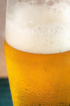 Closeup of a glass of beer with foam and water droplets 