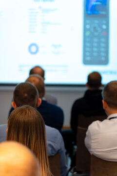 Back view of an audience watching a technical presentation