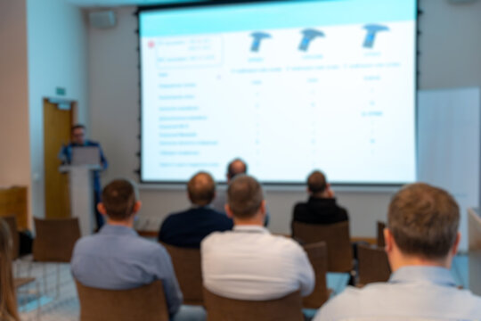 Blurred audience in conference room watching presentation