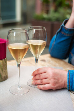 Detail of a woman hands , with two glasses of white sparkling wine, during a wine tasting experience.