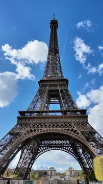 Full Vertical Low-Angle Shot of the Eiffel Tower with Blue Sky