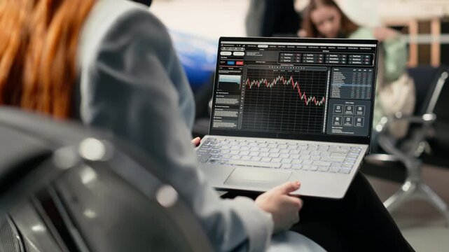 Professional woman reviewing stock charts and financial market insights in airport before departure, using online tools to track algorithms and hedge fund performance. Digital nomad freedom,