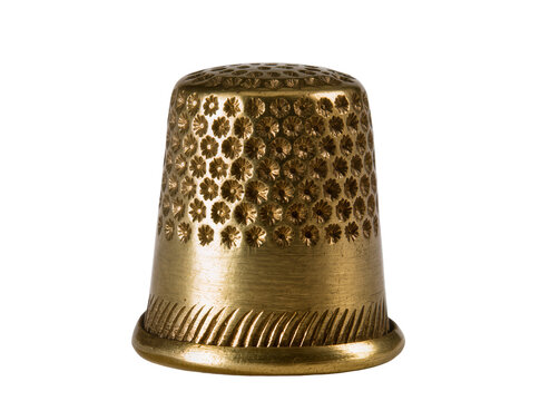 Isolated antique gold metal thimble with intricate floral pattern and textured surface for sewing