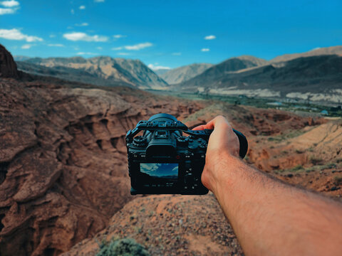 Man holding camera showing landscape view first person perspective