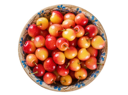 Isolated fresh ripe Rainier cherries in a rustic ceramic bowl with blue floral details, overhead view.
