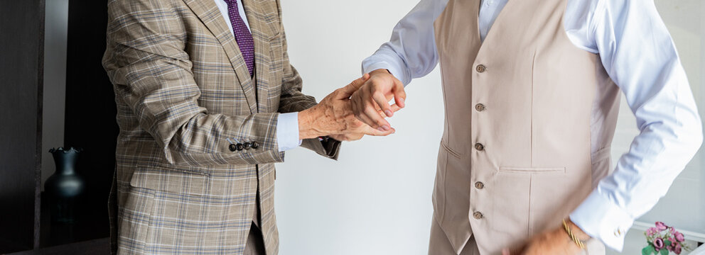 Ajuste de gemelos y detalles de traje durante preparaci&oacute;n elegante masculina