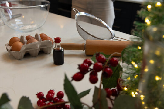 Blurred person wearing apron preparing baking tools on marble countertop with rolling pin, eggs