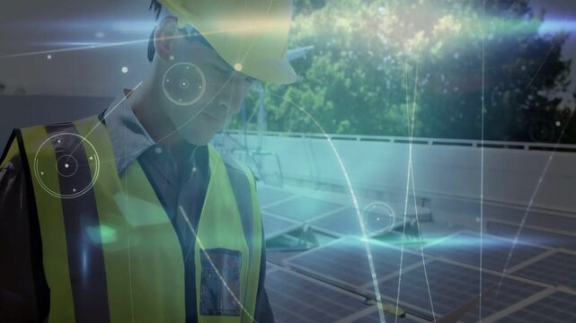Faint light and HUD starting solar tech using laptop donning hardhat checking panels tracking data
