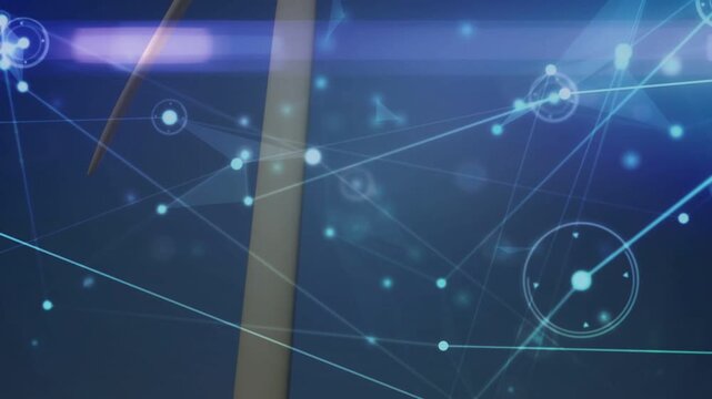 Vertical video: Turbine rotating as camera tilts up, nodes mapping hub and monitoring energy output