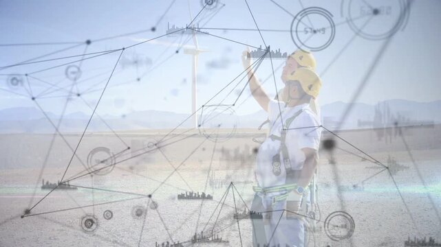 Technician standing arid plain when raising arm pointing up overlay nodes showing turbine data