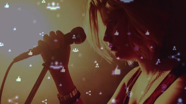 Vertical video: Spotlight cueing singer raising mic and singing for music, icons floating over her