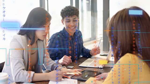 Diverse coworkers reviewing papers at table by windows, tapping tablet, pointing to laptop to plan