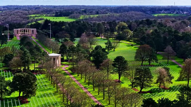 Rows of white crosses at Normandy American Cemetery overlooking Omaha Beach coastline in Normandy France, aerial tracking orbit left