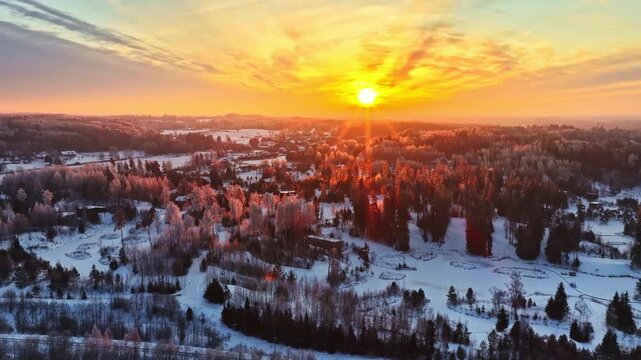 High-detail low flight over a Latvian peat bog. The setting sun illuminates the intricate patterns of ice and frozen vegetation. Latvia