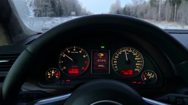 Frozen car dashboard shows minus temperature on a cold winter morning