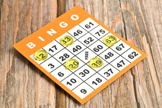 High angle view of a yellow bingo card on a wooden table