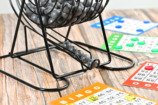 Metal rotary bingo blower with numbered balls and colorful game sheets