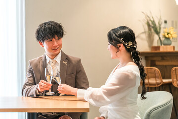 Obraz premium A couple dressed in formal attire chatting while drinking champagne at a restaurant or bar.
