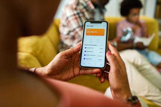 Woman checking mobile banking app at home