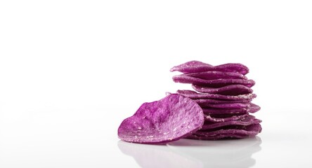 Fototapeta premium A vivid stack of purple sweet potato chips resting on a polished white tabletop with sharp focus and clean white backdrop