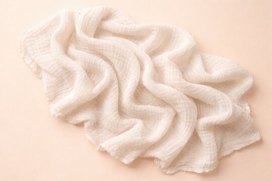 Top view of soft baby muslin blanket with gentle texture on pastel background