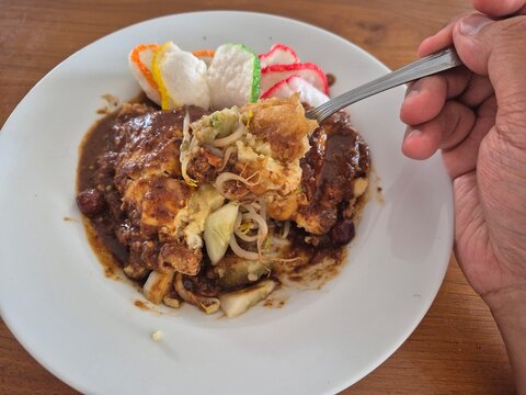 Indonesian tahu telur with peanut sauce, fried tofu egg dish served with crackers and vegetables