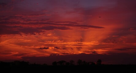 Obraz premium Striking evening horizon with radiant ruby toned clouds