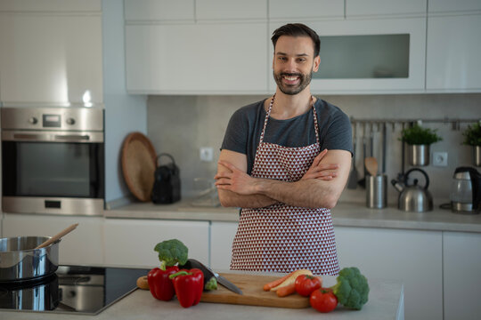 Happy man preparing healthy meal in modern kitchen