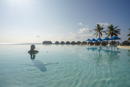 young asian woman relaxing in the swimming pool on an island in the Maldives