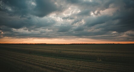 Obraz premium Vintage film styled farmland under a dramatic cloudy sky at early morning sunrise