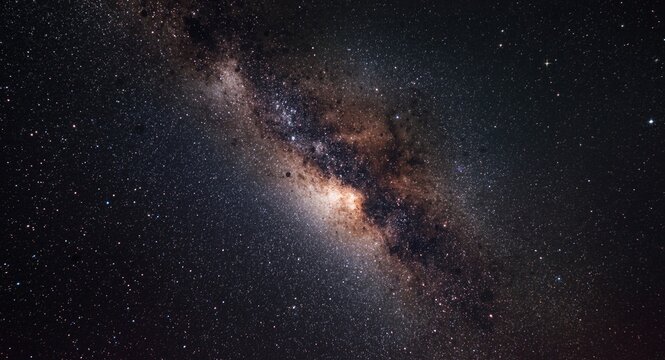View of the Milky Way galaxy center revealing thick space dust layers and sparkling stars under night