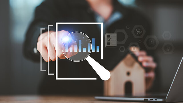 Real estate analysts evaluate property performance using digital charts and magnifying glass interface, representing mortgage data review, housing market research, investment risk assessment