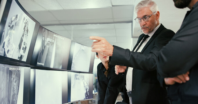 Monitor, manager or security guard with planning in control room, video footage or check cctv blind spot. Computer screen, team or people talk for surveillance weak point, building safety or pointing