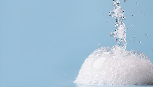 Soap bubbles white foam blue background water splash side view