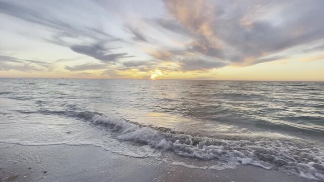 sunset on the beach with ocean waves gently crashing onto Daytona Beach Florida
