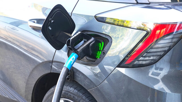 Charging Electric Vehicle: A close-up view of an electric vehicle being charged, showcasing the charging cable connected to the car's charging port.