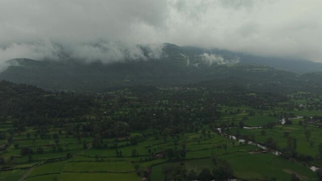 Aerial Drone View of Bhandardara Landscape with Green Valley River and Monsoon Clouds Maharashtra India