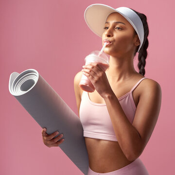Fitness, smoothie and woman in studio with yoga mat, mineral balance and nutrition for post exercise detox. Drink, pilates equipment and person with shake for weight loss, vitamins or pink background