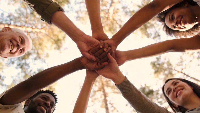 diverse people joining hands in circle