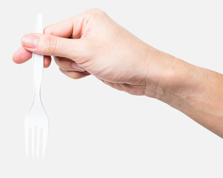 Male hand holding a white plastic fork isolated on white background with clipping path.	