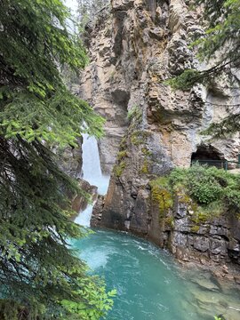 Powerful waterfall flowing through a narrow limestone canyon with turquoise river, Johnston Canyon, Banff National Park, Alberta, Canada.