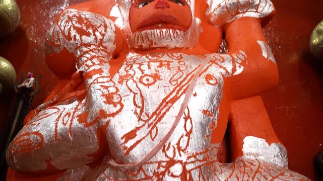 Orange painted Hanuman idol inside Hindu temple with devotional atmosphere