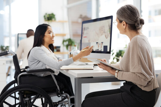 Mentor, wheelchair and women with computer at inclusive office for talking, training or advice at desk. Tablet, screen and happy person with disability, equality and accessibility at workplace