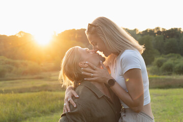 Fototapeta premium Romantic couple embracing closely in golden sunset light in nature