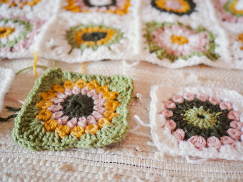 Hand making crochet granny square blanket with yarn
